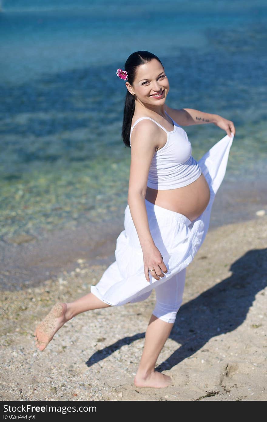 Happy pregnant woman on the beach