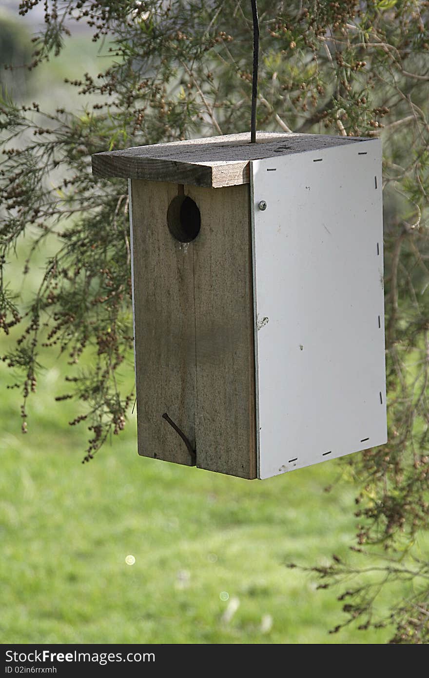 Photo of a bird house hanging from tree. Photo of a bird house hanging from tree.