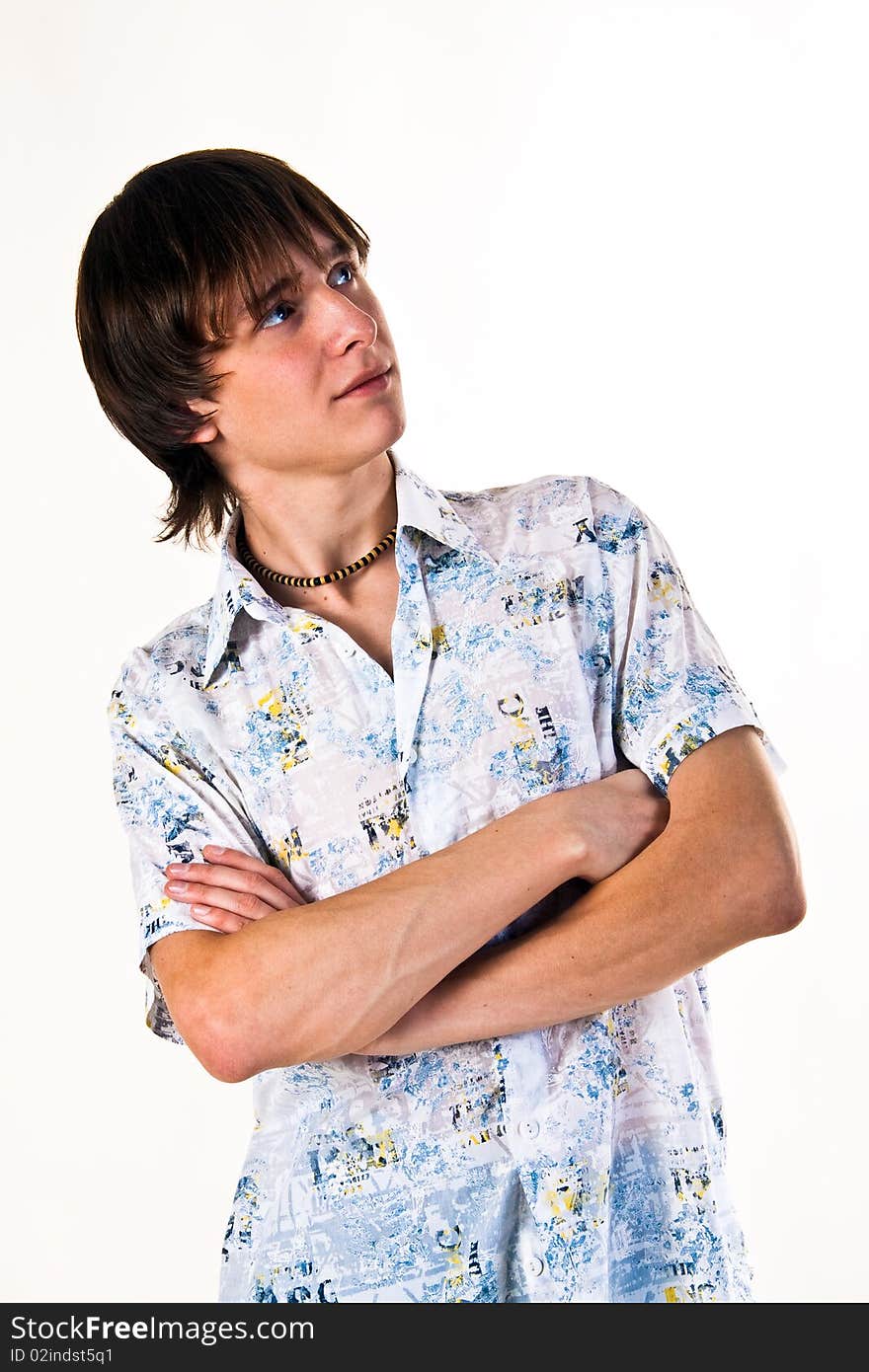 A young male model on a white background wearing a shirt with short sleeves. With the hands combined on a breast. A young male model on a white background wearing a shirt with short sleeves. With the hands combined on a breast.