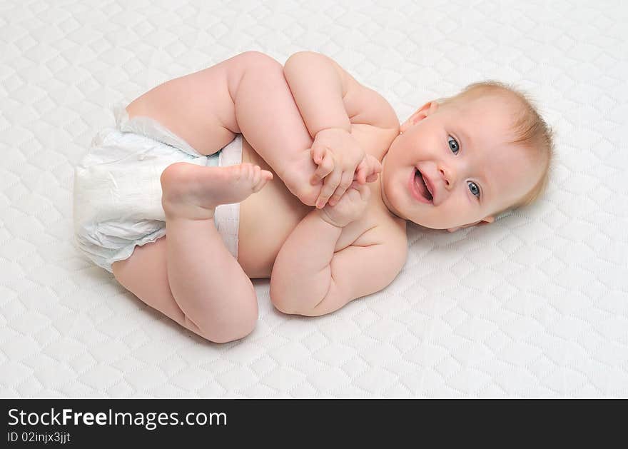 Young baby girl playing with her feet.