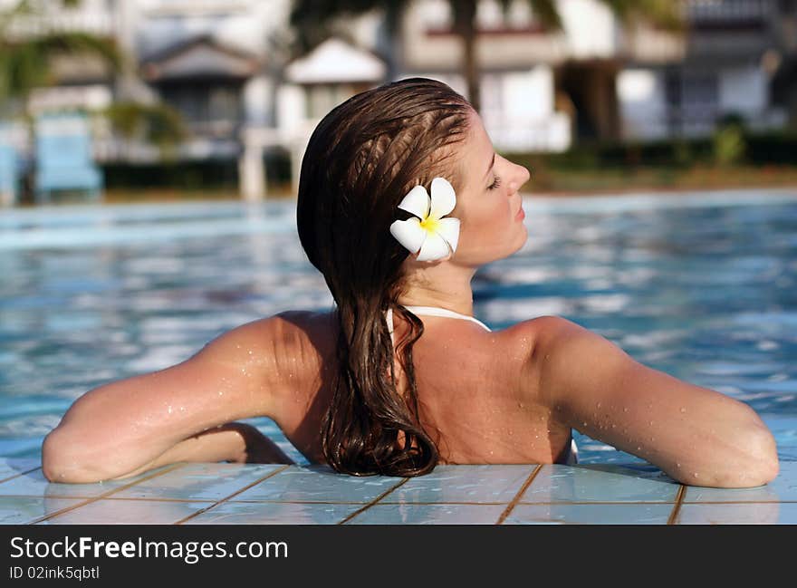 Young beautiful woman with flower in swimming pool. Young beautiful woman with flower in swimming pool