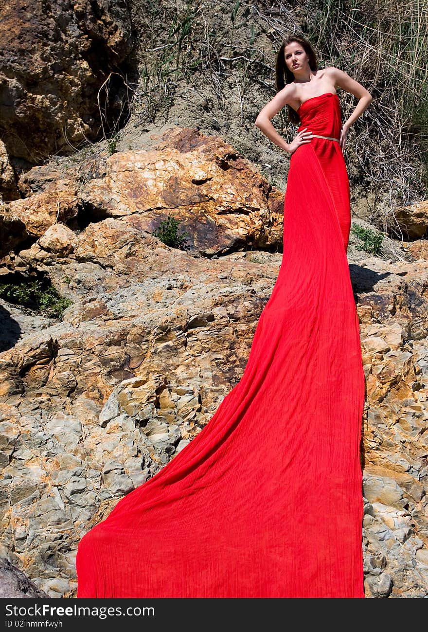 Woman in red dress from material and rocks