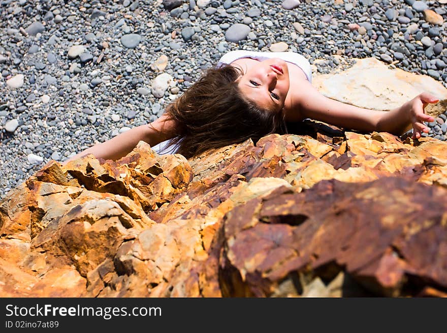 Woman in white dress from material and rocks