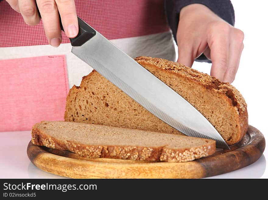 Details cutting bread with knife in closeup