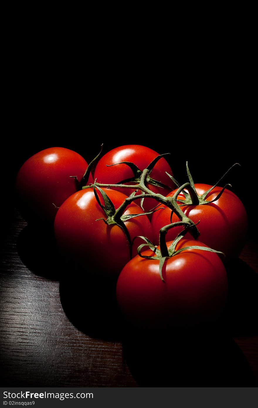 Cluster tomatoes on a black background. Cluster tomatoes on a black background