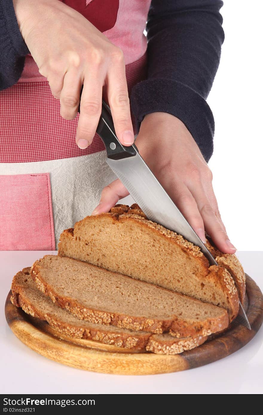 Details cutting bread with knife in closeup