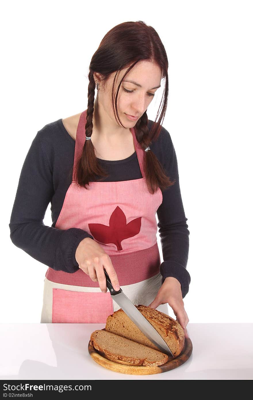 Beautiful housewife cutting bread with knife on white background