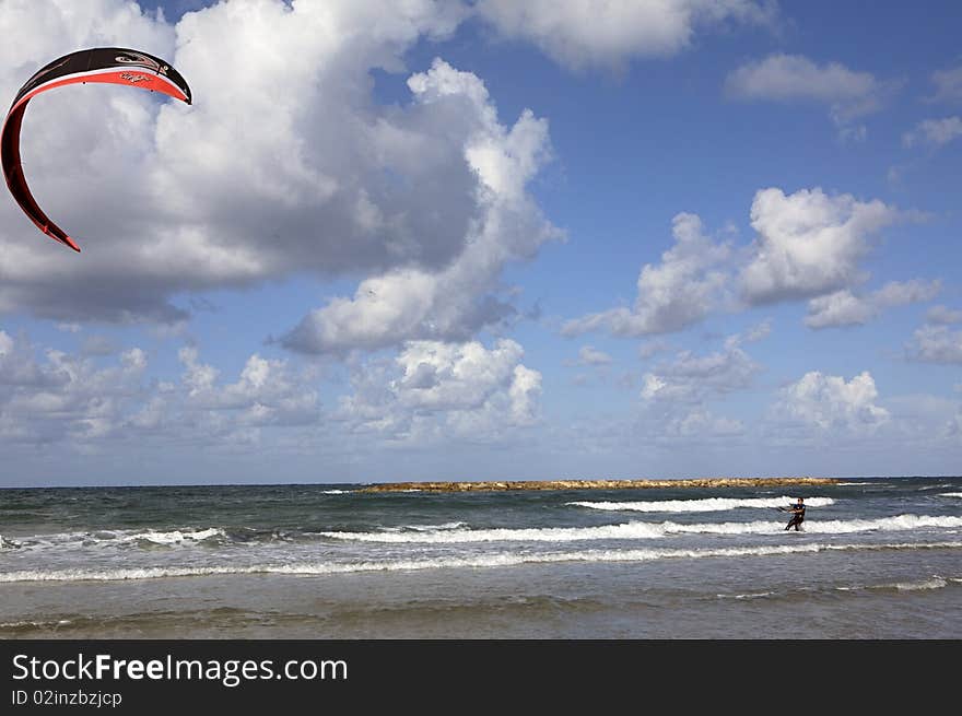 The Kite surfer's sail is full and very much open. The Kite surfer's sail is full and very much open.