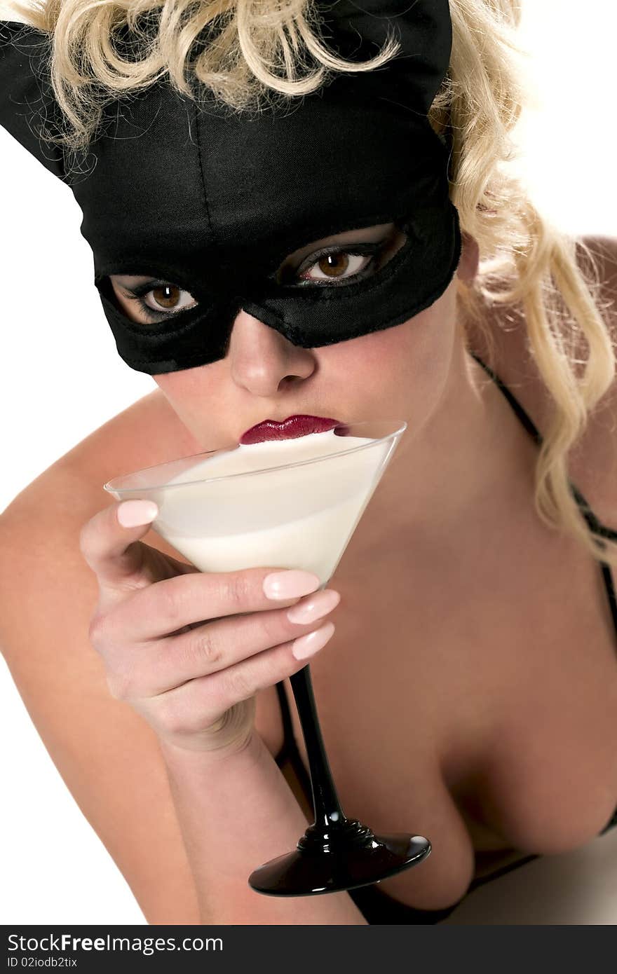 Portrait of the blond model wearing black cat, licking - drinking milk from the martini glass. Portrait of the blond model wearing black cat, licking - drinking milk from the martini glass