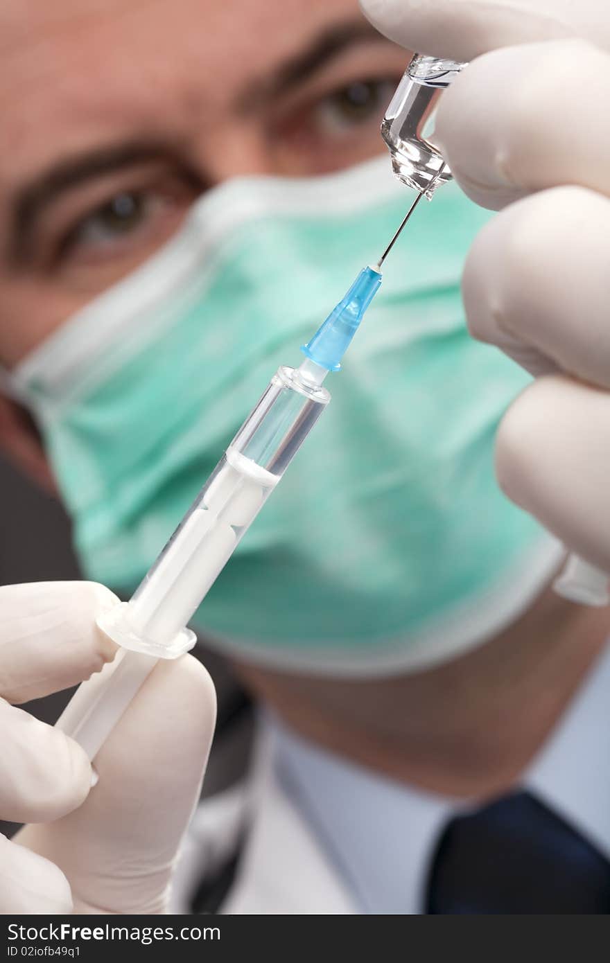 Professional doctor with medical syringe in hands, getting ready for injection