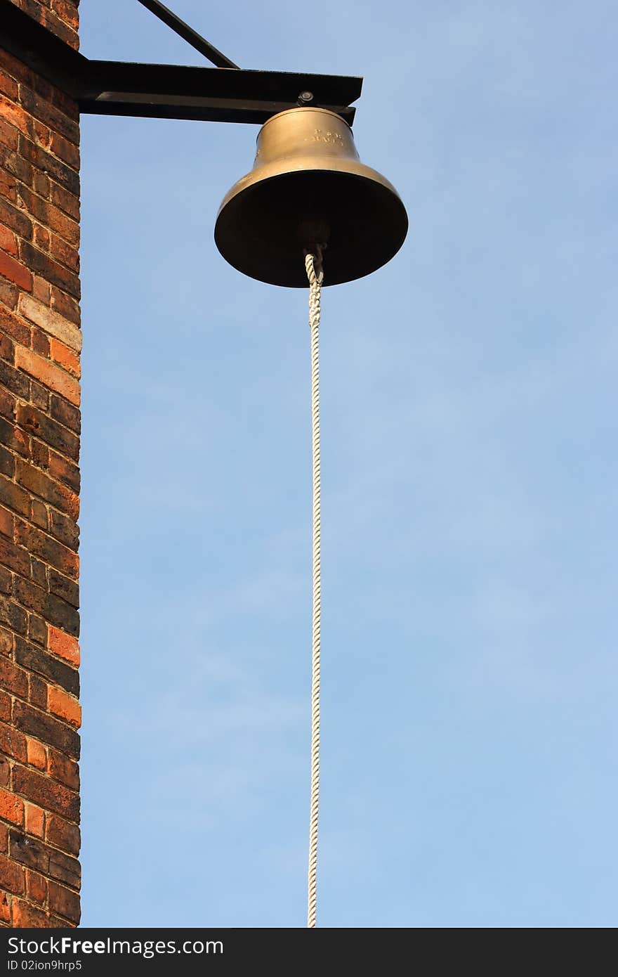 Bell with rope on the corner of the building