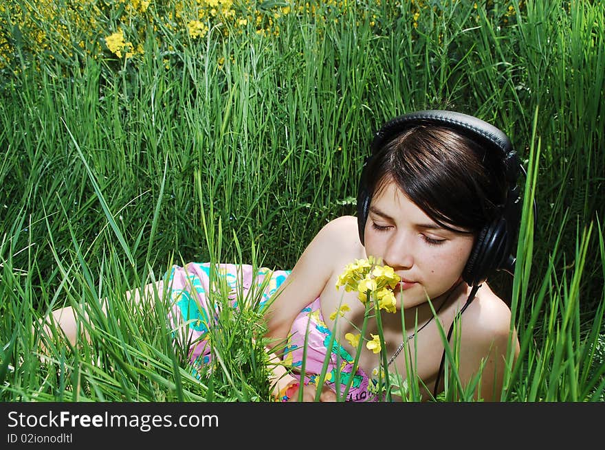 A beautiful young girl listening music in nature. A beautiful young girl listening music in nature