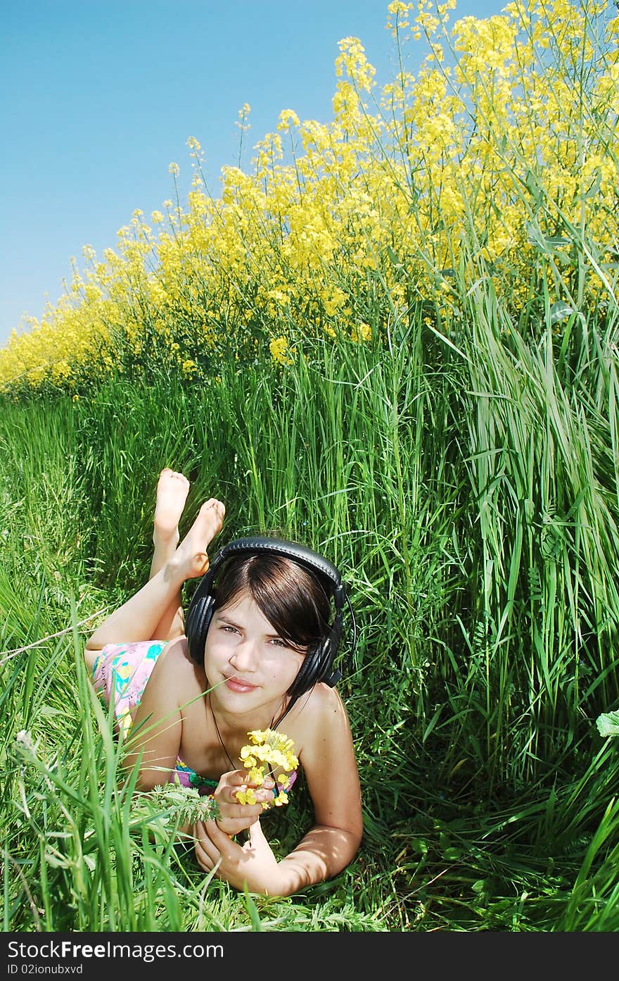 A beautiful young girl listening music in nature. A beautiful young girl listening music in nature