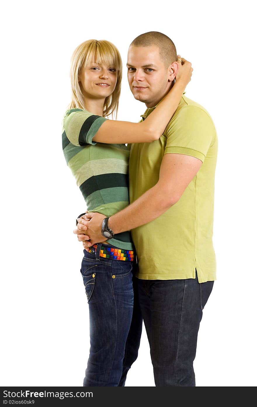 Happy young embracing couple standing  over white background