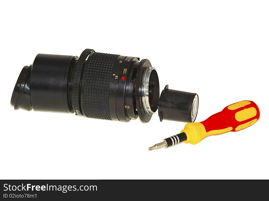 Old dismantled lens with a screwdriver isolated on white background