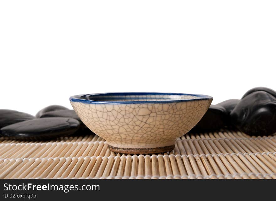 Cup for tea and some stones lie on mat