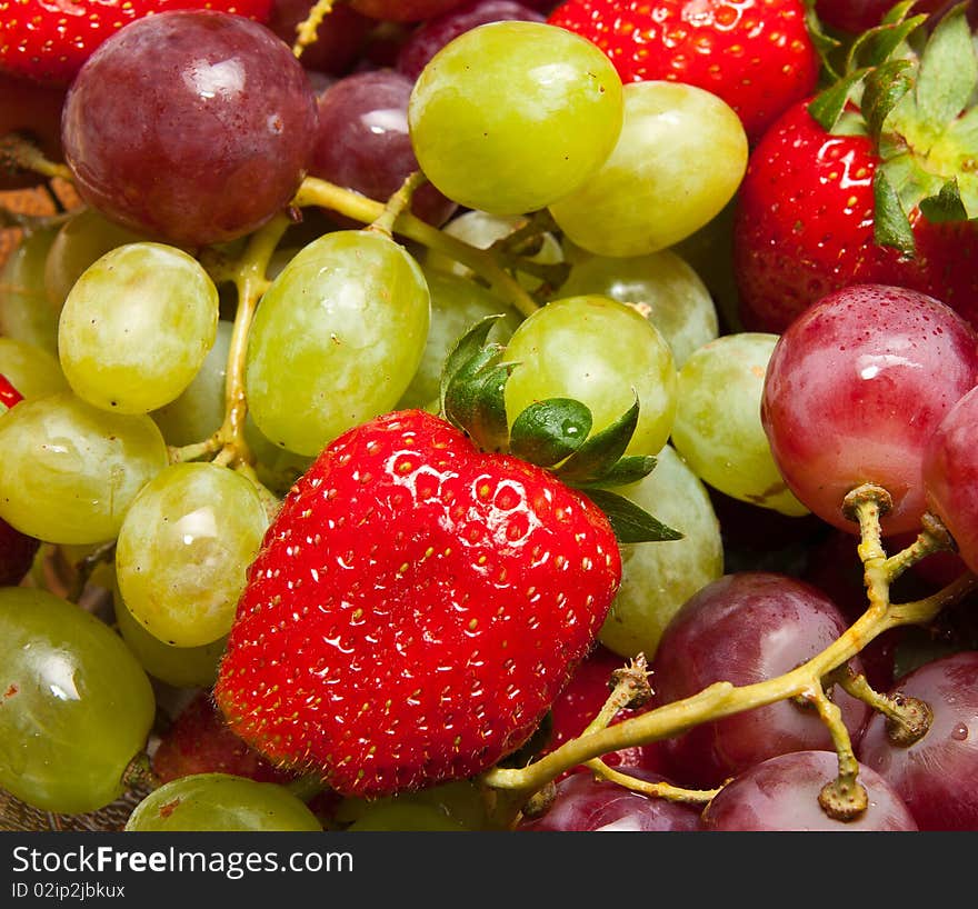 Fresh strawberries and grapes closeup composition