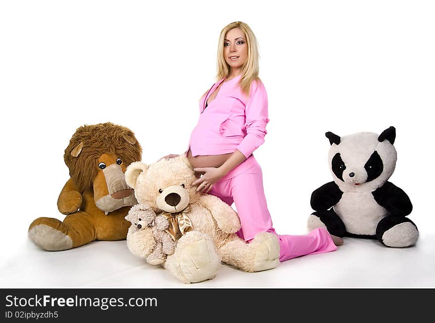 Pregnant girl in pink sports suit with toys on white back