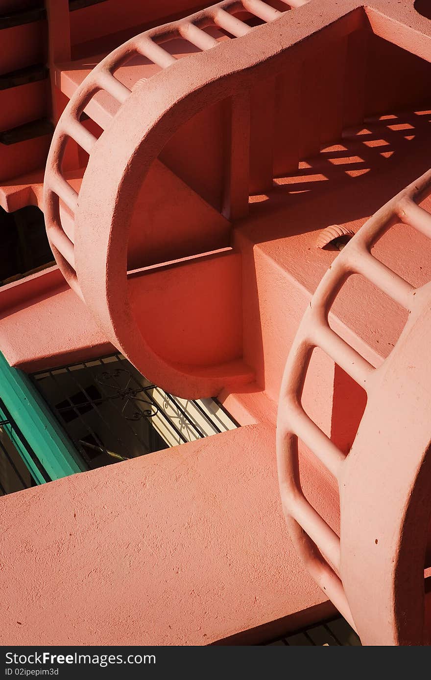 Pink spiral stairs on a warm sunny morning along the coast on the Pacific Ocean in Mexico.