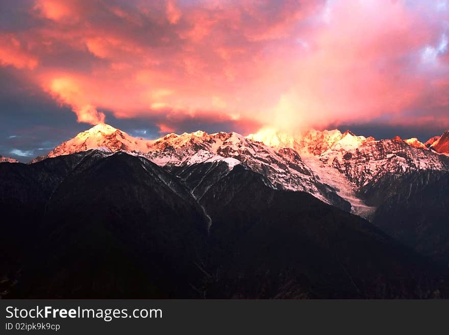 In the fine cloudless weather, as the sun comes out of the Meili Snow Mountain, a ray of sunlight strikes on the summit just like a glaring golden mountain. In the fine cloudless weather, as the sun comes out of the Meili Snow Mountain, a ray of sunlight strikes on the summit just like a glaring golden mountain.