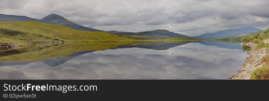 A nameless little lake in the Scottish Highlands reflecting the lonely moodiness of a grey day. A nameless little lake in the Scottish Highlands reflecting the lonely moodiness of a grey day