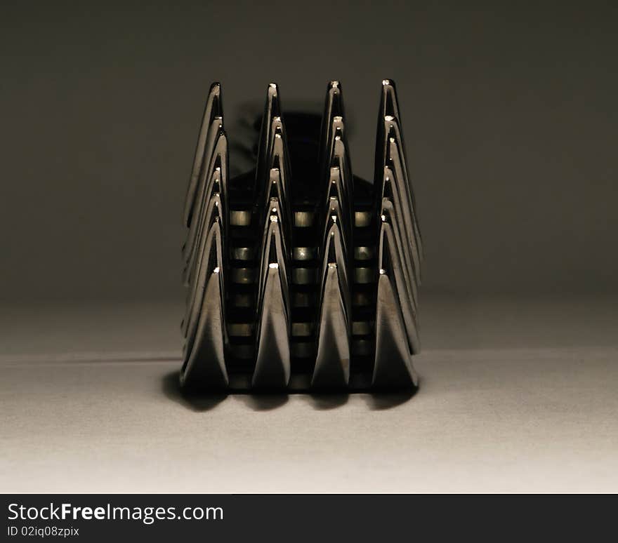 A stack of dinner forks viewed from the pointed ends. A stack of dinner forks viewed from the pointed ends