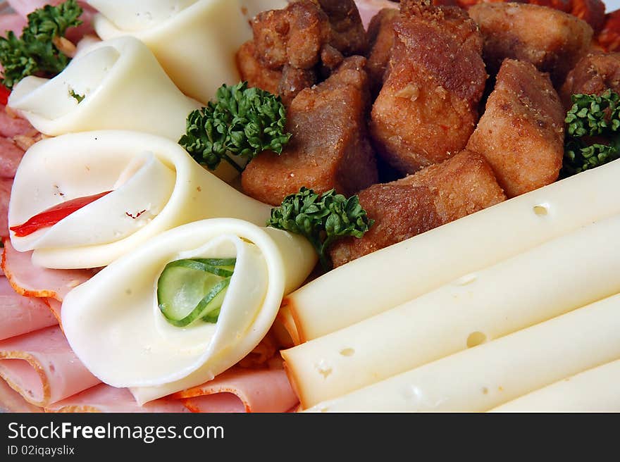 Salami and cheese rolls with vegetables on a plate