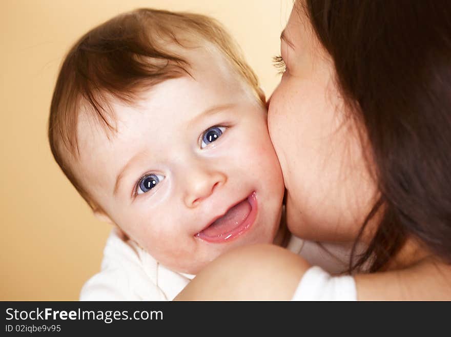 Laughing baby boy in mothers arm; closeup faces