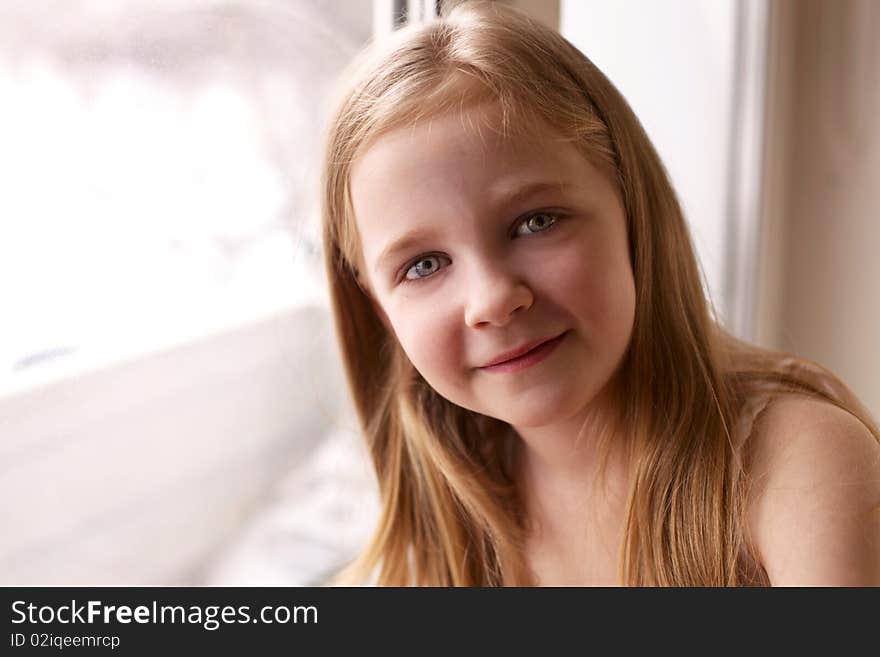 Smiling little girl near window. Smiling little girl near window