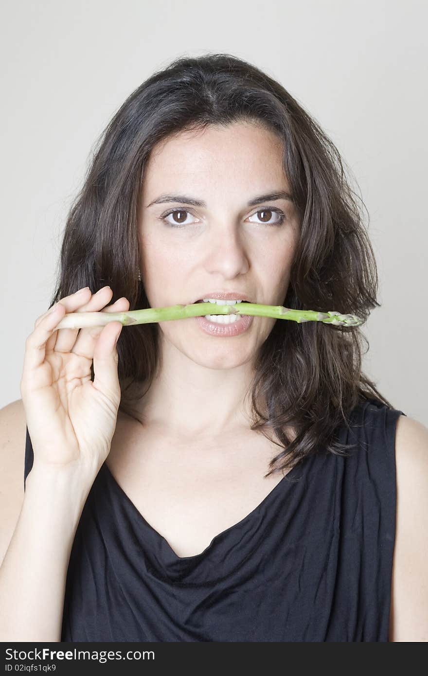 Woman biting asparagus