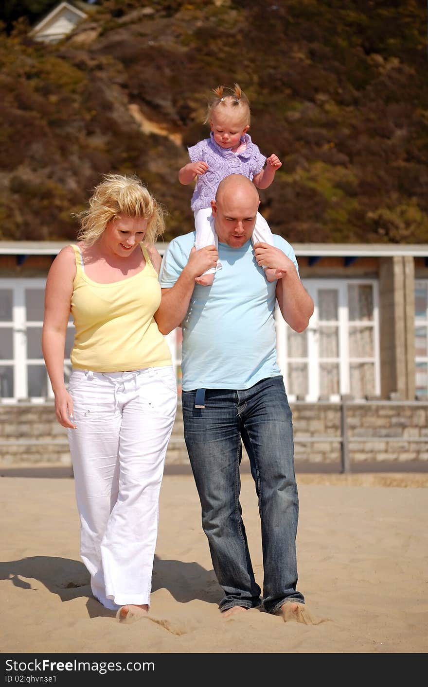 Family enjoying walking along the  beach together. Family enjoying walking along the  beach together