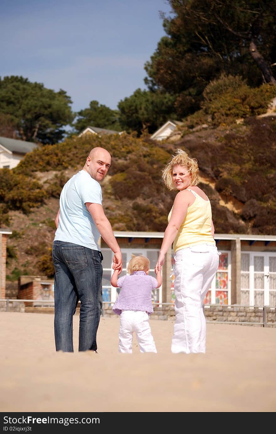 Happy family enjoying walking along the  beach together. Happy family enjoying walking along the  beach together