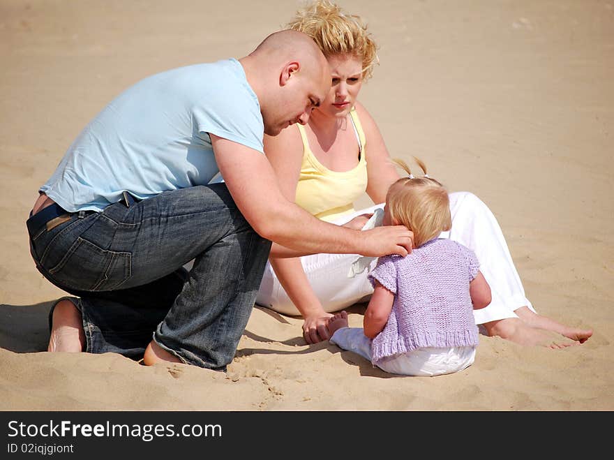 Concerned parents on the beach with their young daughter. Concerned parents on the beach with their young daughter