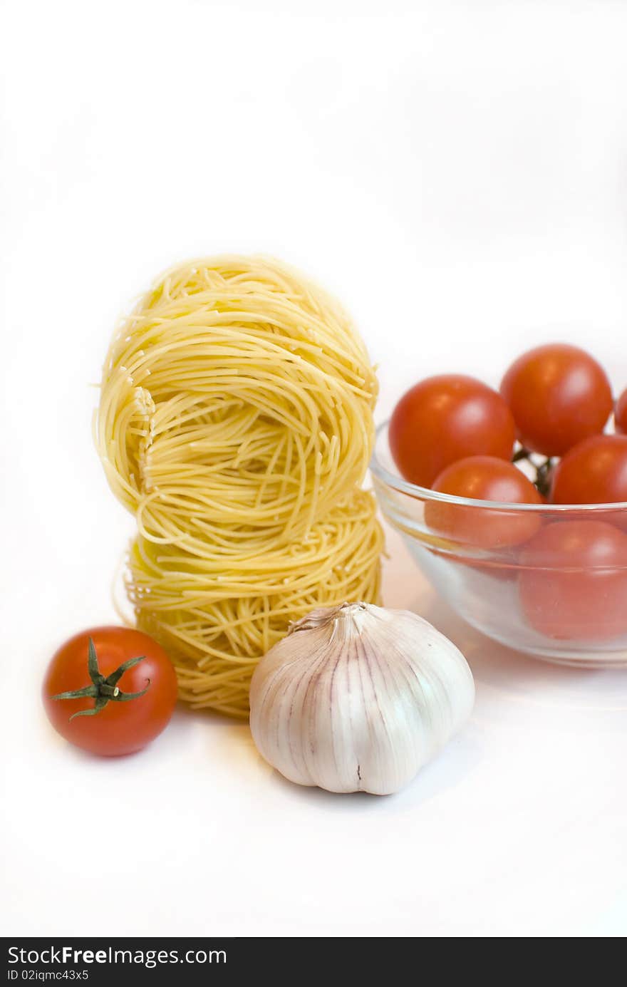 Fresh tomato cherry, garlic and  spaghetti on the white background. Fresh tomato cherry, garlic and  spaghetti on the white background.