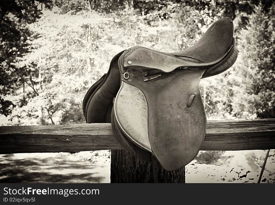 Leather horse saddle on old wooden fence. Leather horse saddle on old wooden fence