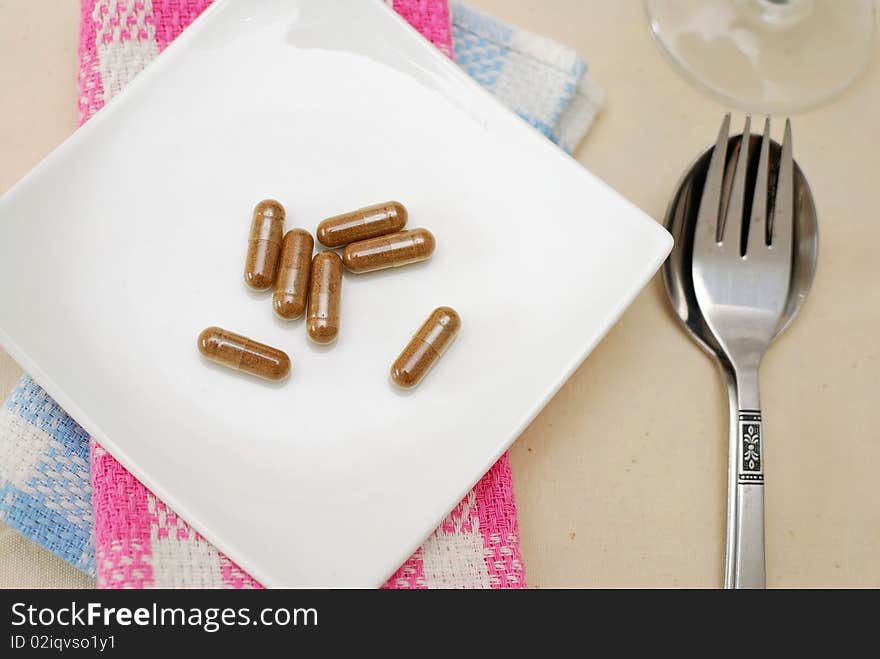 Medicine capsules on dining plate