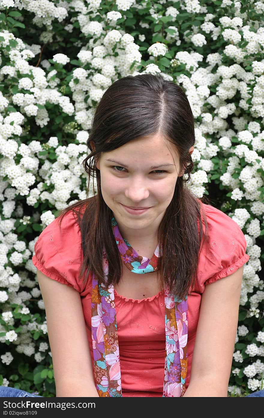 Beautiful girl smells white flowers