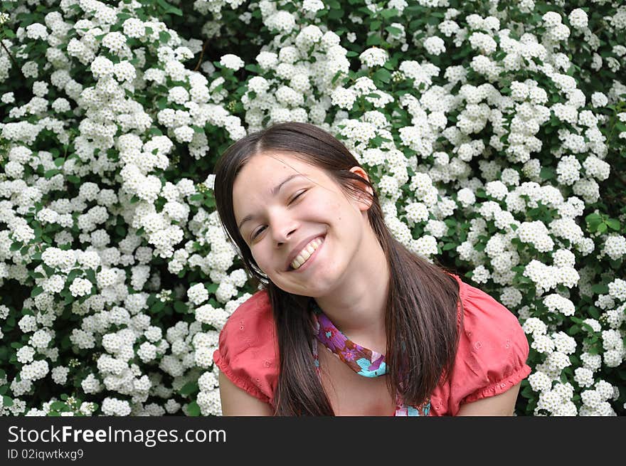 Beautiful girl smells white flowers