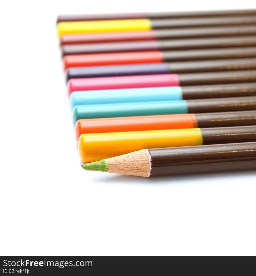 Colored pencils and a unique green on a white background. Colored pencils and a unique green on a white background