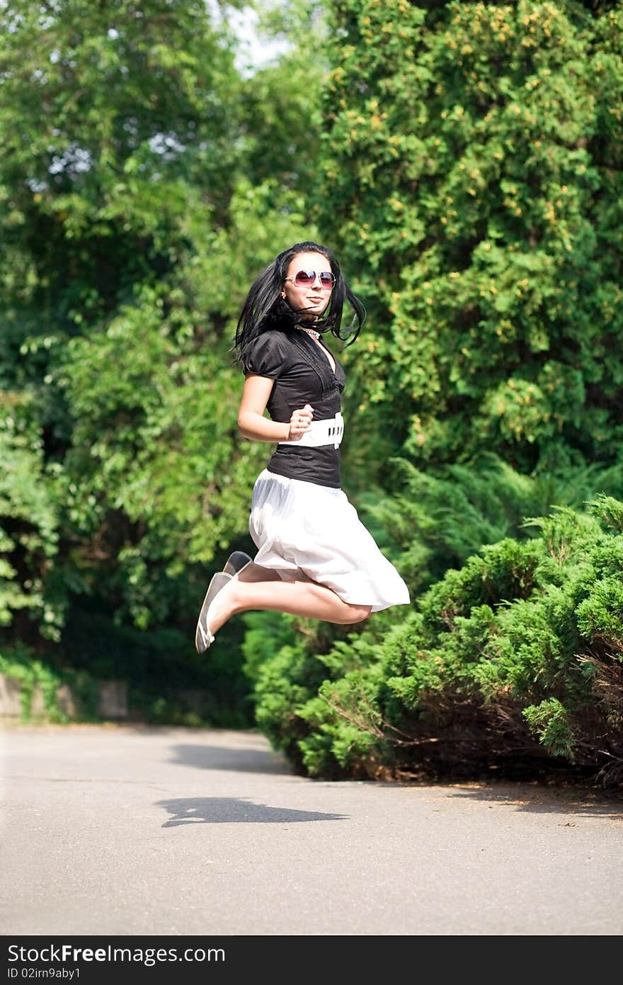 Happy young woman jumping and enjoying the summer