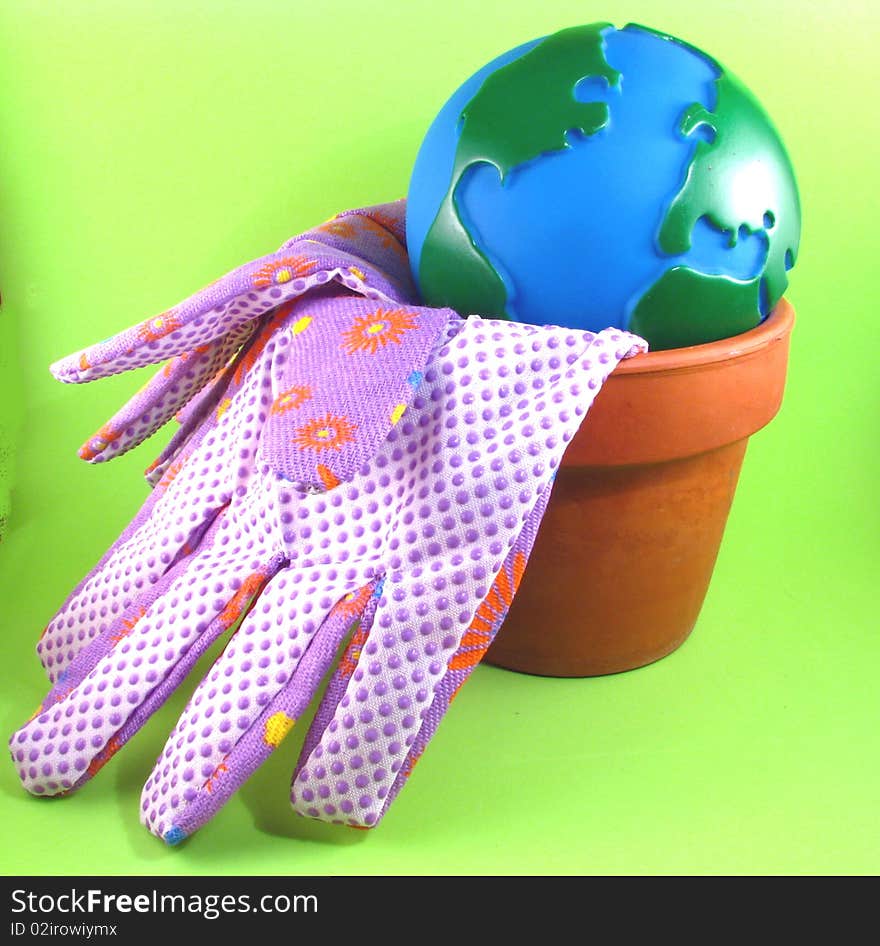 Globe in a flower pot with gardening gloves. Globe in a flower pot with gardening gloves