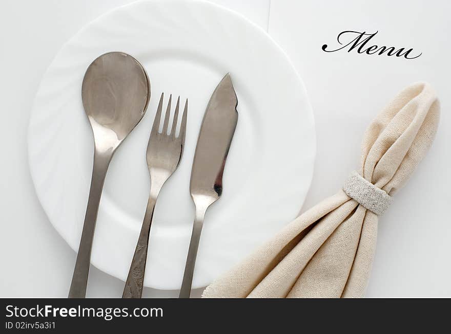 An image of fork, spoon and knife on a plate. An image of fork, spoon and knife on a plate