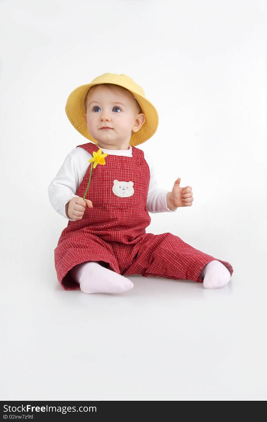 Sitting little girl in hat and with flower on white background. Sitting little girl in hat and with flower on white background.