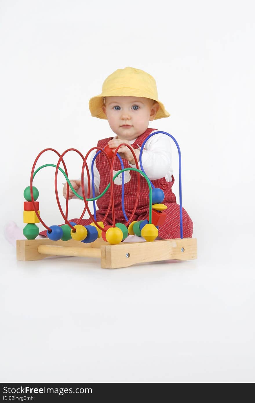 Baby girl playing with a colorful beads on a wire,on white background. Baby girl playing with a colorful beads on a wire,on white background.