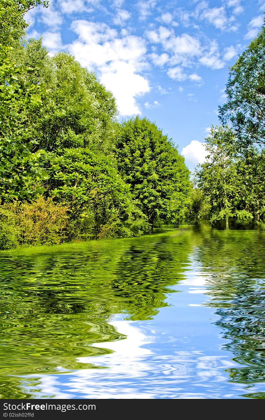 Summer landscape with trees, lake and cloudy sky in HDR style