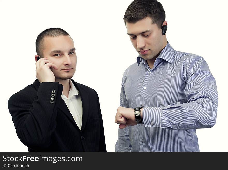 Two business people talking on the phone and watching at clock. Two business people talking on the phone and watching at clock