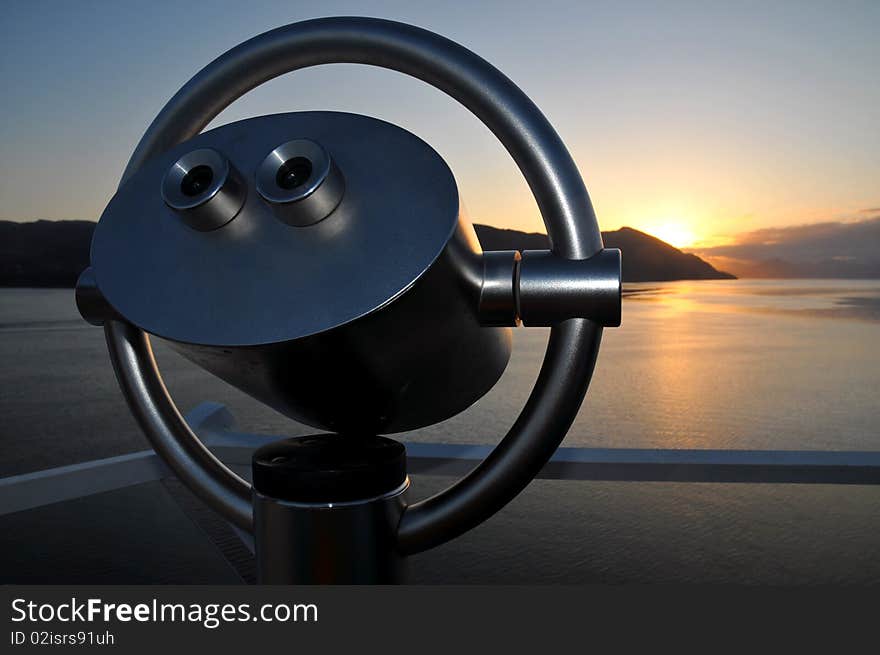 Scenic lookout binoculars at sunrise at the Norwegian fjord