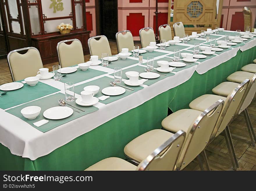 Table setting in the chinese restaurant. Chinese characters on the background wall is Blessing.