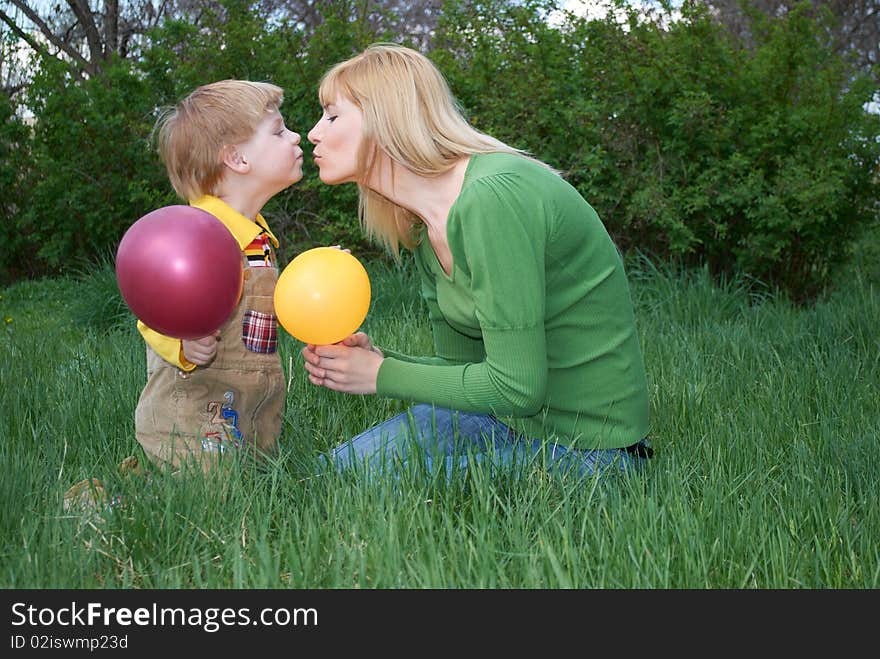 Mum with the son are played with balls in the spring on the nature. Mum with the son are played with balls in the spring on the nature