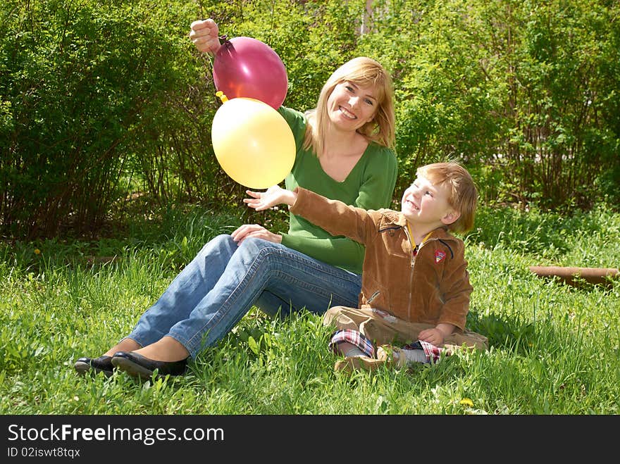 Mum with the son are played with balls in the spring on the nature. Mum with the son are played with balls in the spring on the nature